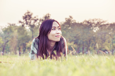 an asian woman is on a grass field in vintage colorの写真素材