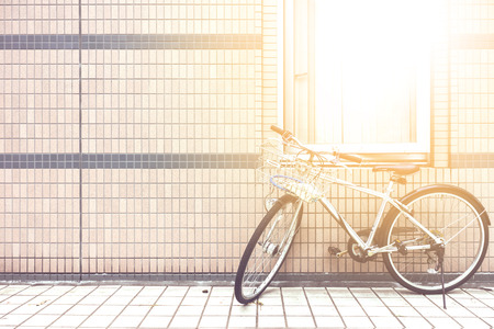 bicycle near the wall with the sun among the windowの写真素材
