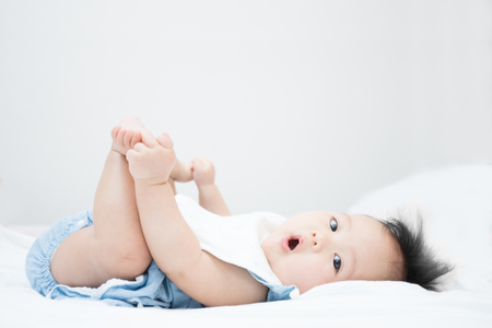 a baby just touch her feet for first time which is  normal development of babyの写真素材