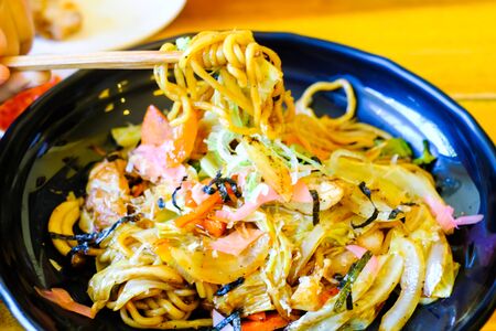 Eating Stirfried pork and Ramen style noodle fried with chopsticksの写真素材