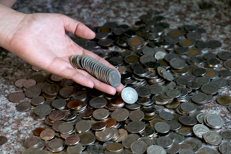 Hand women putting money (coins) on floor. Investment and Interest Concept.