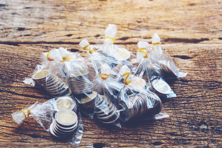 coins in plastic bag on wood sunlight background, Wooden with money and thai coins