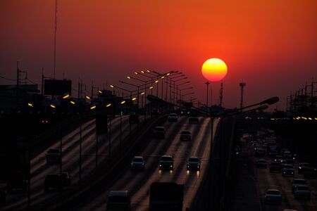 Cars are in a traffic during a beautiful golden sunset in a big city, thailand bangkokの写真素材