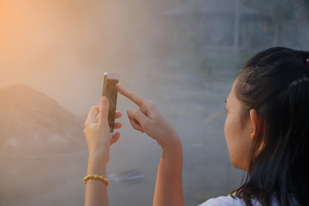 young asian woman showing your smartphone screen, summer park outdoors, Mobile phone with black blank screen, thailand girlの写真素材