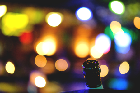 bottle background concert lights bokeh.Concept Festive Celebrations, Bottle of whiskey on bokeh at night street background with copy space, Celebration with champagneの写真素材