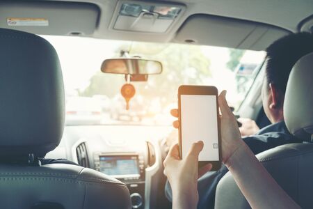 Close-up of woman's hands holding smartphone in the car interior, blank screen for text and contentの写真素材