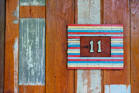 11, eleven, numeral of wood combined with yellow insert, plate and wood for background, empty spaceの写真素材