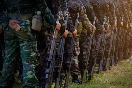 Soldiers stand in row. Gun in hand. Army, Military Boots lines of commando soldiers in camouflage uniforms Thailandのeditorial素材