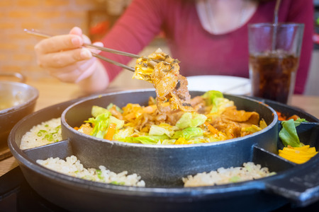 Dak Galbi Seafood on hot pan, Korean food spicy stir-fried chicken. hand use chopsticksの写真素材