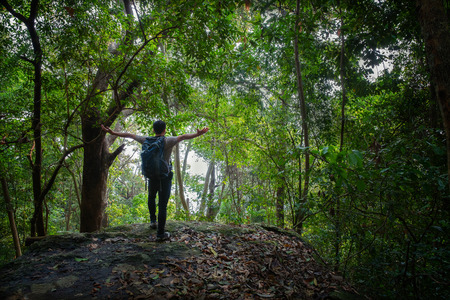 young hipster Man puts bag on shoes footwear in travel nature background, Thailand