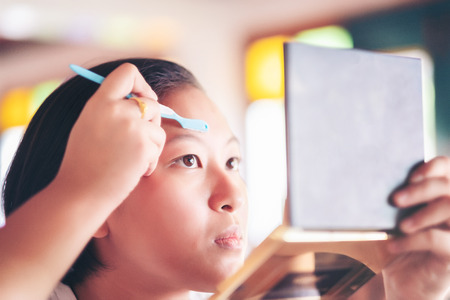 lady shave Brow. young attractive asian woman beauty image, makeup artist used eyebrow razor makeup...