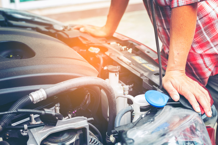 Hand of auto mechanic with a wrench. Car repair mechanic checking car engine in cars service.の写真素材