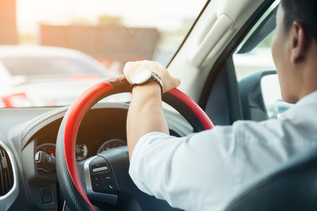 Car driver hands holding steering wheel.