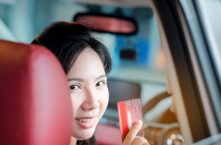 Happy woman thai sitting inside her new car showing credit card, Women Asiaの写真素材