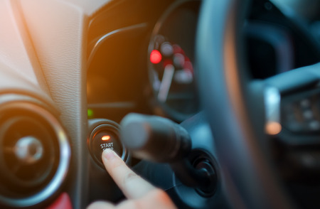 closeup hand pushing on car start engine, Woman driver pushing a start ignition button switch in the...