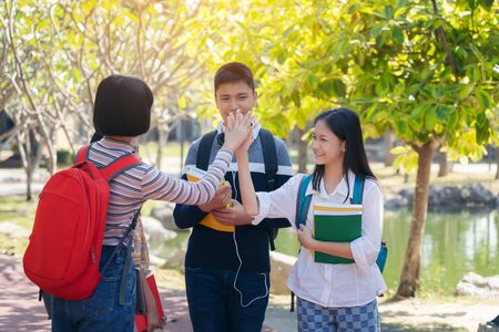 Group of student happy young people touch hands outdoors, Diverse Young Students Book Outdoors Conceptの写真素材