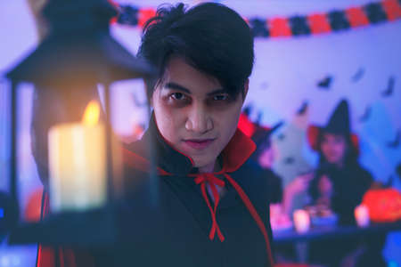 Young man in Costumes Celebrating Halloween having Fun at Party in Nightclub by doing Scary faces.の写真素材