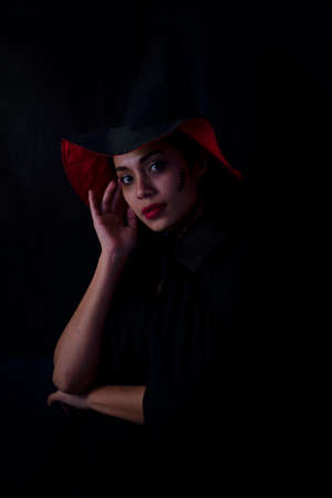 Young brunette woman in black hat and costume, Attractive thai asia female model. Halloween Portrait of attractive with red lipstickの写真素材
