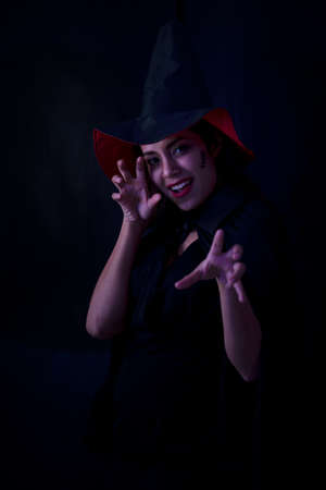 Young brunette woman in black hat and costume, Attractive thai asia female model. Halloween Portrait of attractive with red lipstickの写真素材