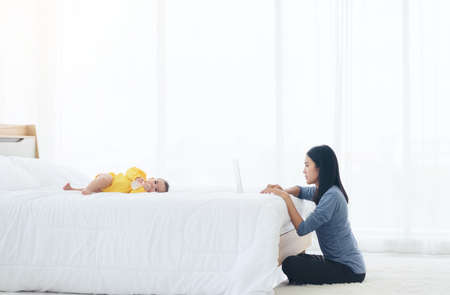 Mom and baby with laptop computer working from homeの写真素材