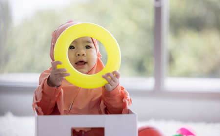 Muslim Baby plays with colorful toys in the living room