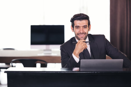 Portrait of happy businessman sitting at office desk