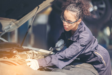 Mechanic repairing the motor or electric parts of a car in a garage