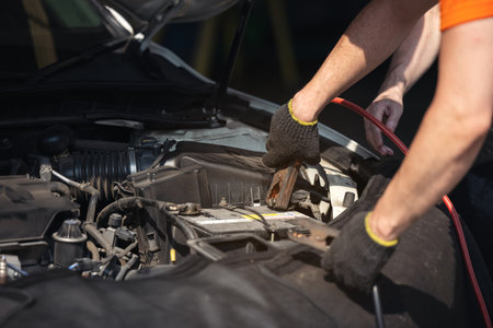 Battery charger and car in auto repair shop,Auto mechanic working in garage. Repair service.の写真素材