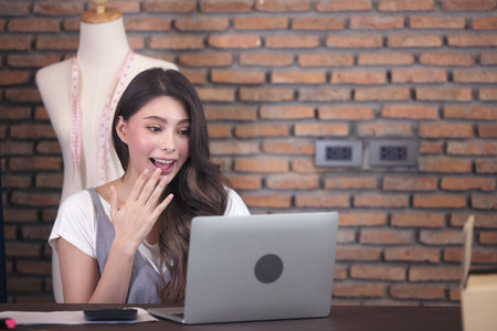 Young business woman working selling online. Surprise and shock face of asian woman success on...