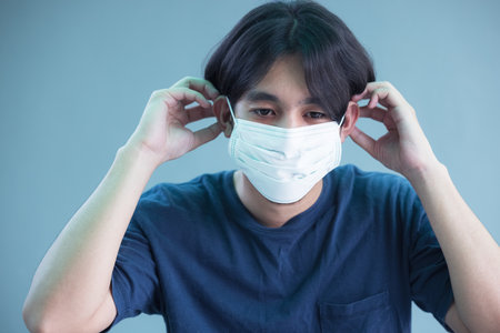 Close up of young man in sterile face mask isolated background.の写真素材