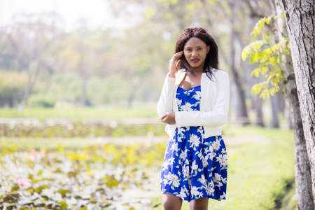 Beautiful young black woman smiling outdoors in autumnの写真素材