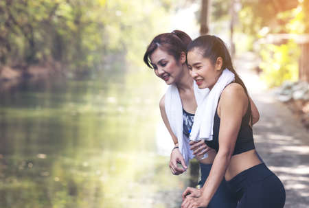 Runners fitness couple running in the city park, Two women exercising by joggingの写真素材