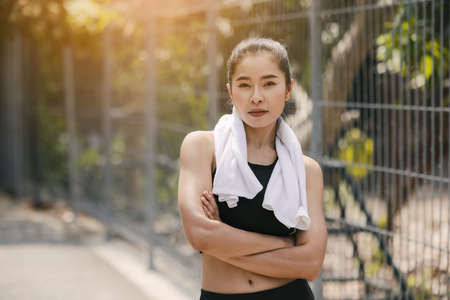 Young woman stretching body after jogging, Happy sporty millennial woman running on quayの写真素材