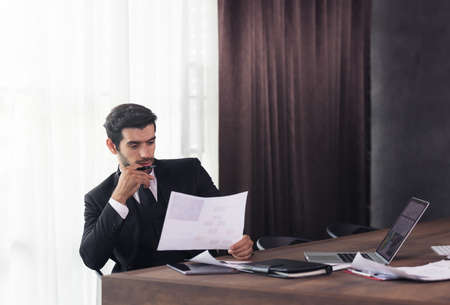Young businessman working at home and thinking of something