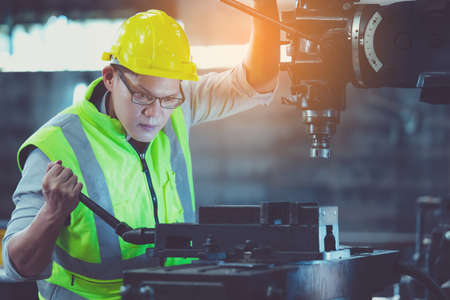 Professional engineer metalworker operating machine center in manufacturing workshop, check security...