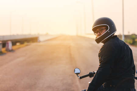 Young man riding big bike motocycle on asphalt high way against, Motorbike man has freedomの写真素材