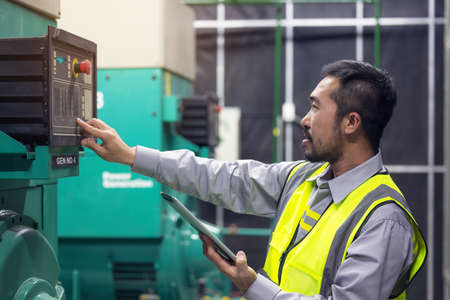 Close up hand of engineer or electrician man working check the electrical system with tablet at...