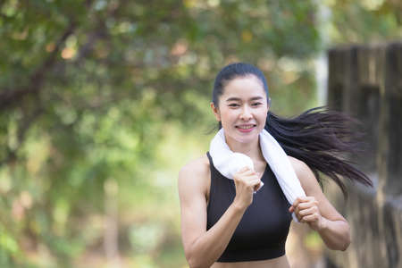 Beautiful woman running near bridge during sunsetの写真素材