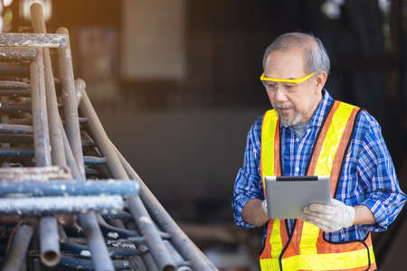 Male carpenter in a construction workshop, using a digital tabletの写真素材