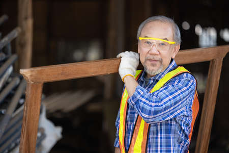 Carpenter, Senior man sanding wooden fence in workplace using work toolの写真素材