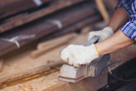 Carpenter, Senior man sanding wooden fence in workplace using work toolの写真素材