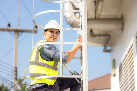 Young man worker or engineer climb ladder.