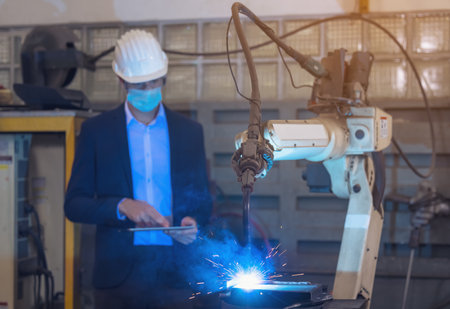 Engineer check and control automation robot arms machine in intelligent factory industrial on real...