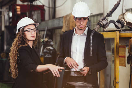 Engineer with digital tablet supervising autonomous producton process