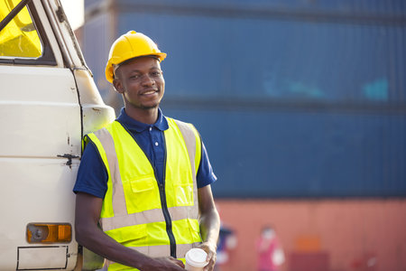 African American businessman drinking coffee, black man have coffee break at worksite outdoors container backgroundの写真素材
