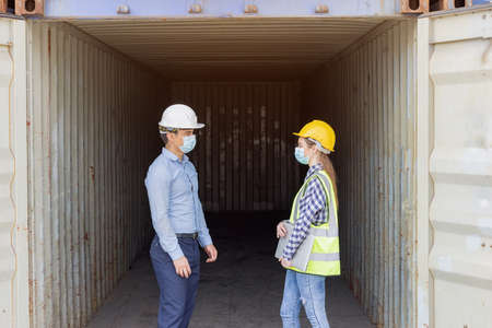 Industrial worker woman and engineer control worker checking in front door of cargo container at container cargo harborの写真素材