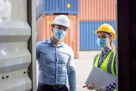 Industrial worker woman and engineer control worker checking in front door of cargo container at...