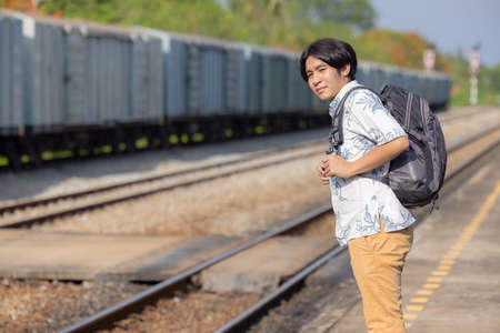 Young asian traveler with backpack in the railway, Backpack and hat at the train station with a traveler, Travel conceptの写真素材
