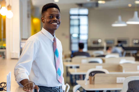 Friendly and smiling young african american professional businessman looking at camera in modern officeの写真素材