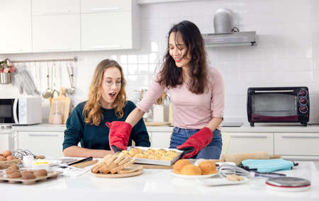 Beautiful baker making pastries, Cute happy two Women have fun a bread making classroom and use...
